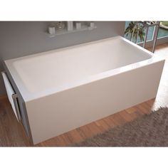 a white bath tub sitting on top of a wooden floor