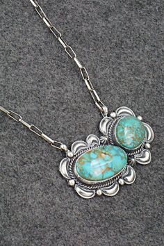 This stunning natural Kingman turquoise and sterling silver necklace was made by Navajo silversmith Raymond Delgarito. The back is signed RD and stamped sterling.Necklace: 20" with additional 3 1/2" extender chainPendant Length: 1 3/8"Pendant Width: 2 3/4"Free shipping on all orders! We ship with USPS and always include tracking. All orders ship within a day of payment.Returns are accepted up to 30 days after you receive your order. Just send us a message. Our shop offers cash back or store cred Western Style Collectible Turquoise Sterling Silver Necklace, Western Sterling Silver Turquoise Pendant Necklace, Western-style Sterling Silver Turquoise Pendant Necklace, Western Style Turquoise Pendant Necklace In Sterling Silver, Southwestern Sterling Silver Collectible Necklace, Southwestern Sterling Silver Turquoise Necklace, Southwestern Sterling Silver Turquoise Necklace Collectible, Southwestern Turquoise Sterling Silver Collectible Necklace, Southwestern Sterling Silver Turquoise Necklace With Large Pendant