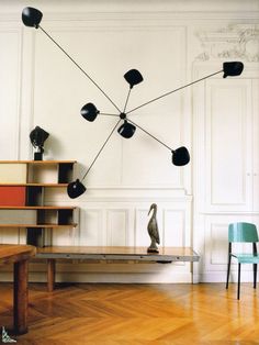 a black and white photo of a living room with chairs, bookshelves and lamps