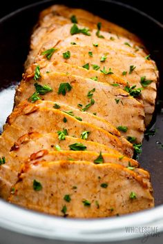 some meat is being cooked in a pan on the stove top with garnishes