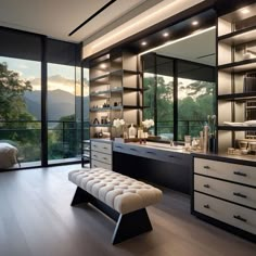 a modern bathroom with large windows overlooking the trees and mountains in the evening light, along with a bench that is upholstered by glass doors