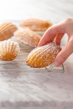 a person picking up some powdered sugar from a cooling rack