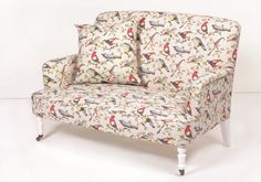 a white chair with birds on it sitting in front of a white wall and floor