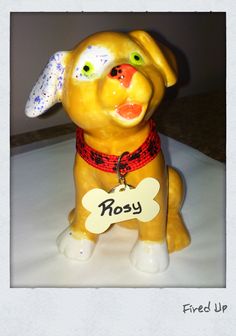 a yellow dog figurine with a bone tag on it's collar and nose