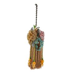 a decorative hanging decoration with flowers on it's side and a black string in the middle