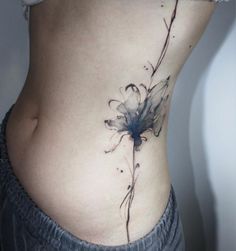 a woman's stomach with a flower tattoo on it