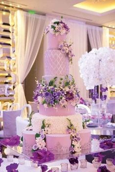 a wedding cake with purple flowers and greenery