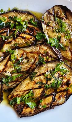 grilled eggplant with herbs on a white plate