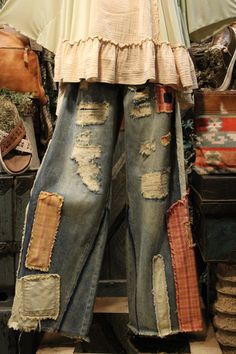 an old pair of jeans with holes and patches on them, sitting in front of a mirror