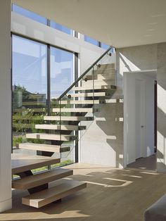 the stairs in this modern house are made of wood and glass, with no railings