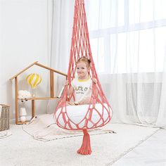 a little boy is sitting in a hammock