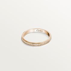 a rose gold ring with white diamonds on the side and an inscription that reads cartier