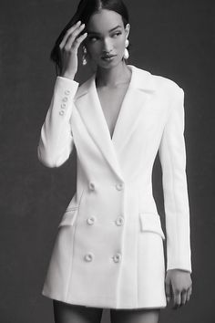 Embodying sleek sophistication and feminine allure, the MISHA Ander Dress captivates with its striking v-neckline and daring mini length, all tailored into a beautifully structured, double-breasted blazer silhouette. | Ander Mini Blazer Dress Jacket by MISHA in White, Women's, Size: XS, Polyester/Elastane at Anthropologie White Tuxedo Dress Women, Double Breasted Outfit Women, Wedding Dress With Blazer, Wedding Blazer Women, Tuxedo Dress Wedding, Tuxedo Dress Outfit, Jacket Dresses For Women, Blazer Dress Outfits Classy, White Suit Dress