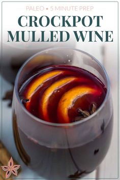 a close up of a wine glass with fruit in it and text overlay that reads, paleo 5 minute prep crockpot mulled wine