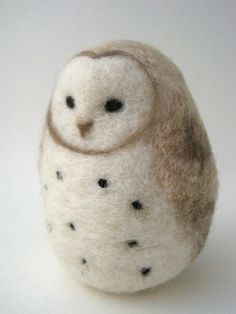 an owl made out of wool with black dots on it's eyes and nose