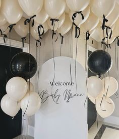 white and black balloons are hanging from the ceiling