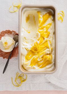 an ice cream dish with lemon zest in it and two spoons next to it