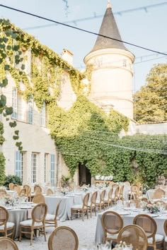 an outdoor dining area with tables and chairs set up in front of a large building