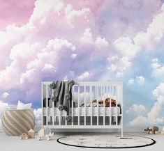 a baby's room with clouds painted on the wall and a crib in the foreground