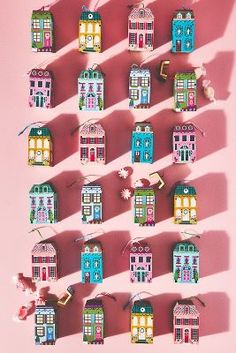 many small houses are arranged on a pink surface with shadows from the sun shining through them