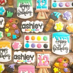 decorated cookies with happy birthday messages on them are displayed in front of a wooden table