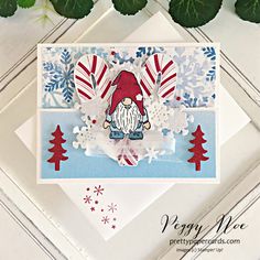 a christmas card with snowflakes, trees and a gnome on it's back