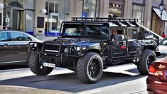 a black jeep driving down a street next to parked cars