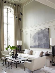 a living room filled with furniture and a large painting hanging on the wall above it