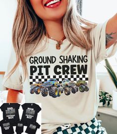 a woman wearing a shirt that says ground shaking pit crew with four monster trucks on it