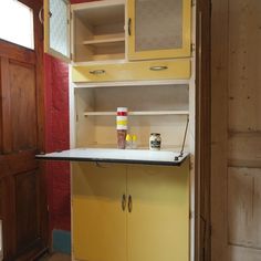 a kitchen with yellow cabinets and white counter tops