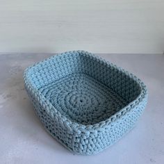 a blue crocheted basket sitting on top of a table