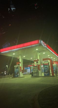 an empty gas station at night with the lights on