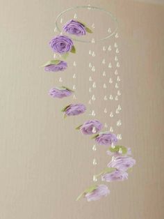 purple flowers are hanging from the ceiling with beads and water droplets on them, along with pearls