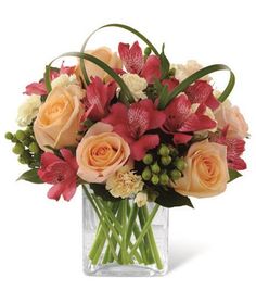 a vase filled with assorted flowers on top of a table