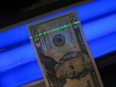 a one dollar bill is lit up with blue light