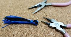 two pairs of pliers are laying on the floor next to each other with blue tassels