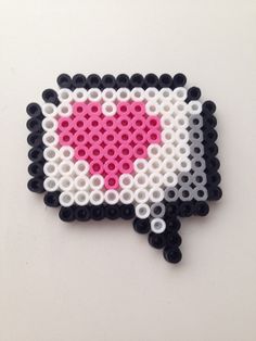 a piece of art made out of legos with a pink heart in the middle