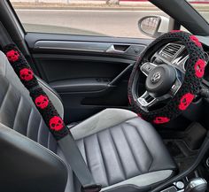 the interior of a car with red skulls on it's steering wheel and dashboard