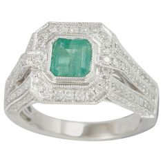 This spectacular ring from the Suzy Levian Limited Edition collection features a Colombian emerald gemstone held in a 14K white gold basket setting. An array of side white diamonds (1.13ct) with hand-carved French filigree work across the band, accents the perfect white gold color of the emerald cut center stone emerald (1.02ct) The brilliance of these gems and the luster of the high-polish finish of the white gold creates an eye catching piece of jewelry. Art Deco Emerald, Gold Basket, Basket Setting, Colombian Emeralds, Emerald Gemstone, Ring Ring, Cocktail Rings, Emerald Cut, Diamond White