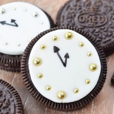 oreo cookies are decorated with white and gold frosting to look like an analog clock