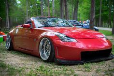 a red sports car parked in the woods