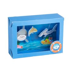 a blue box with two toy sharks in the water and an orange life preserver