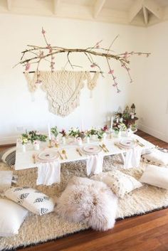 the table is set with white linens and pink flowers