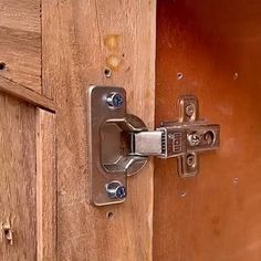 an open door with a metal latch on it's side and wood paneling