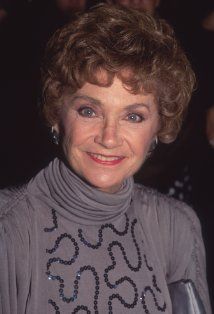 an older woman is smiling for the camera while wearing a turtle neck sweater with sequins on it