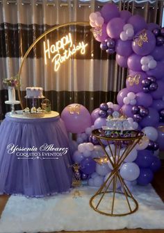 a purple and white birthday party with balloons