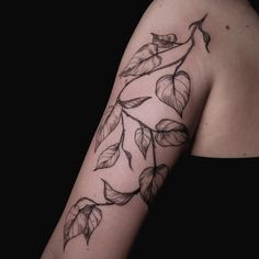 a woman's arm with leaves on it