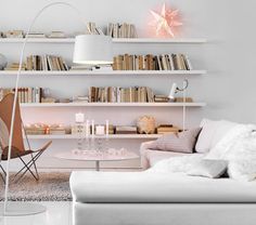 a white living room filled with furniture and bookshelves