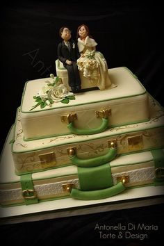 a wedding cake made to look like suitcases with bride and groom figurines on top