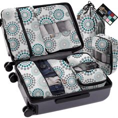 four pieces of luggage with blue and white circles on it, including one suitcase full of clothes